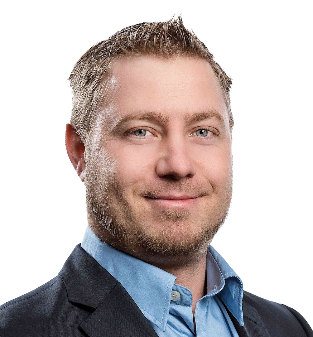 Das Bild zeigt eine Person mit einer verpixelten Gesichtsfläche in einem Business-Outfit vor weißem Hintergrund.